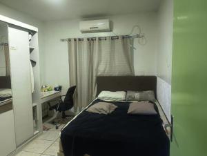 a bedroom with a bed and a desk and a window at FICOS Hospedagem in São Gabriel