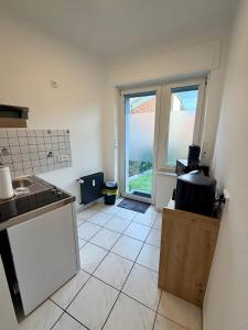a kitchen with a stove and a large window at Modernes Studio im Herzen von Würselen, gemütlich, zentral & mit Netflix in Würselen