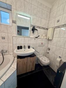 a bathroom with a sink and a tub and a toilet at Modernes Studio im Herzen von Würselen, gemütlich, zentral & mit Netflix in Würselen