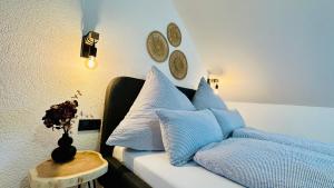 a white couch with blue pillows and a table at T&P FamilyHaus in Bad Sooden-Allendorf
