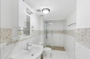 a white bathroom with a sink and a toilet at designer abode condo min to Manhattan in jersey city in Jersey City +14 photos