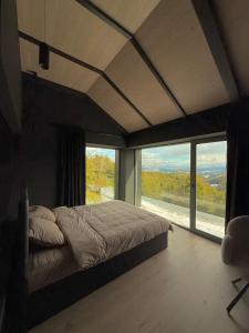 a bedroom with a large bed with a large window at Nordic Star Chalet in Fundata +48 photos