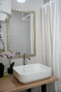 ein Badezimmer mit einem weißen Waschbecken und einem Spiegel in der Unterkunft Porichka Home in Roslavichi + 38 Fotos
