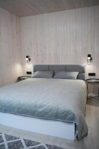 ein Schlafzimmer mit einem großen Bett mit zwei Nachttischen in der Unterkunft Porichka Home in Roslavichi