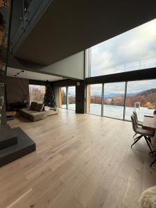 a large living room with wooden floors and large windows at Nordic Star Chalet in Fundata