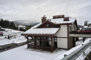 a building with snow on top of it in the snow at Cristal Garden Chalet in Bukovel