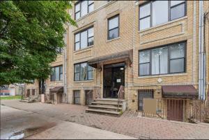 a brick building with a staircase in front of it at designer abode condo min to Manhattan in jersey city in Jersey City