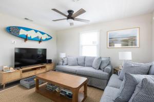 un salon avec un canapé et une télévision dans l'établissement Newly Updated Cottage in the Heart of KDH, à Kill Devil Hills