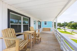une véranda avec des chaises, une table et une fenêtre dans l'établissement Newly Updated Cottage in the Heart of KDH, à Kill Devil Hills