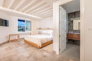 ein weißes Schlafzimmer mit einem Bett und einem Badezimmer in der Unterkunft Neira Boutique Hotel & Spa in Sidi Bou Saïd + 36 Fotos