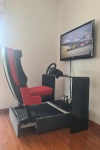 ein Wohnzimmer mit einem roten Sessel und einem Flachbildfernseher in der Unterkunft Chalet con Piscina de,3 hab in Dílar