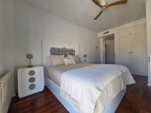 ein weißes Schlafzimmer mit einem Bett und einem Deckenventilator in der Unterkunft Chalet con Piscina de,3 hab in Dílar + 15 Fotos