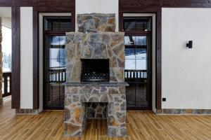 a stone fireplace in the middle of a room at Cristal Garden Chalet in Bukovel