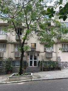 a building with a tree in front of it at Estúdio na melhor rua do Leblon in Rio de Janeiro