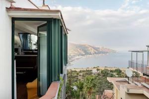 een balkon van een gebouw met uitzicht op het water bij DIMORA DISIU - Jacuzzi & Sea View - 4 minuti a piedi dal centro in Taormina