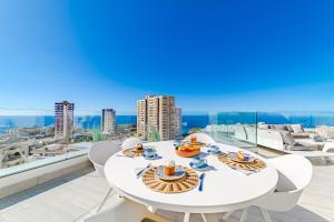 a white table and chairs on a balcony with a view at White Haven in Adeje