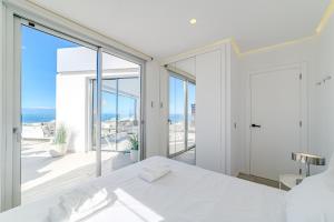 a bedroom with a white bed and a view of the ocean at White Haven in Adeje +49 photos