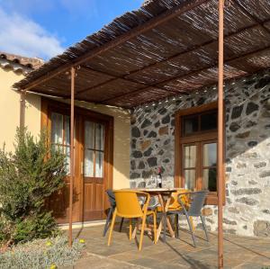 a wooden pergola over a table and chairs on a patio at Casa Gecko in Tijarafe