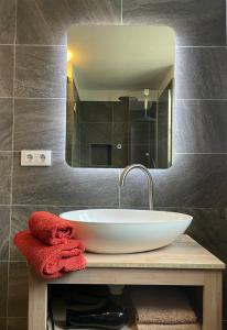 a bathroom sink with a mirror and a red towel at Casa Gecko in Tijarafe