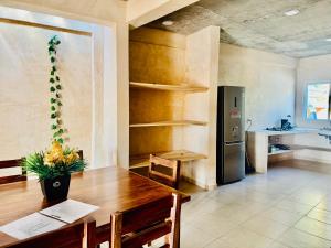 a kitchen with a wooden table and a refrigerator at Casa Tachu in Puerto Escondido