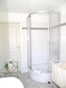 a white bathroom with a tub and a shower at Birkmaase 12 - Kapitänshaus Jacqueline 4-Sterne Komfort FeWo im EG links in Zingst +1 photo