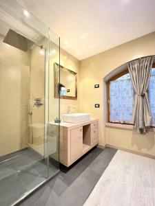 a bathroom with a glass shower and a sink at tabià piz meda in Moena