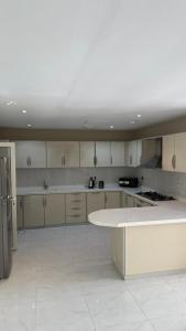 a large white kitchen with a white counter top at فيلا هابي بيتش درة العروس رملي وخاص in Durat Alarous