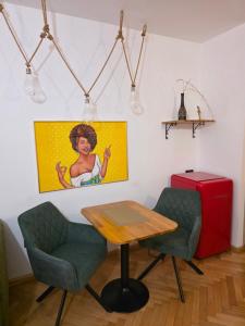 ein Tisch, zwei Stühle und ein roter Koffer in der Unterkunft Luky10 in Braşov