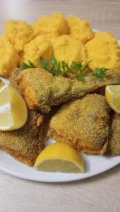 a plate of food with fish and potatoes and lemon slices at Harmony Retreat in Dealu Negru +38 photos
