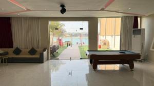 a living room with a pool table and a couch at فيلا هابي بيتش درة العروس رملي وخاص in Durat Alarous