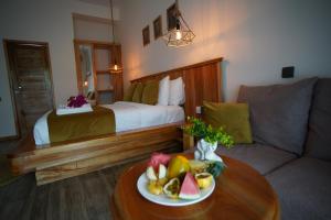 a hotel room with a bed and a table with a plate of fruit at Oasis Nungwi in Kendwa Mchangani