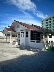 una casa blanca con un edificio al fondo en Charin pool villa - Aurora Villa 9, en Ban Pa Yup