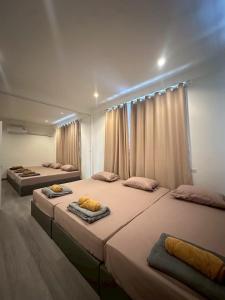 2 camas grandes en una habitación con cortinas en Charin pool villa - Aurora Villa 9, en Ban Pa Yup