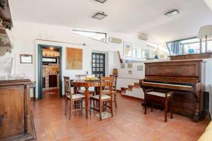 een woonkamer met een tafel en een piano bij DIMORA DISIU - Jacuzzi & Sea View - 4 minuti a piedi dal centro in Taormina