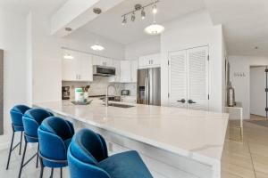 una cucina con armadi bianchi e sedie blu di Tides 611 a Destin