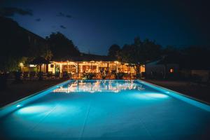 a swimming pool lit up at night at Hameau du Prat in Ribes