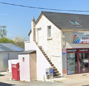 a building with a staircase in front of a store at Le Petit Dagonneau in Varennes Vauzelles