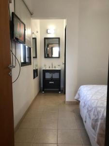 Un baño con una cama y un lavabo en una habitación. en Cuatro Estaciones, en San José