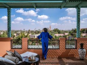 a woman standing on a balcony looking out at the city at Sofitel Marrakech Palais Impérial & Spa in Marrakech