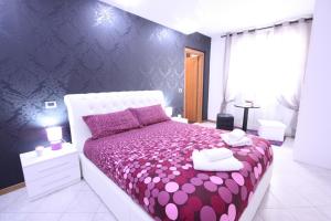 a bedroom with a purple bed with a purple comforter at Black and White in Cantù