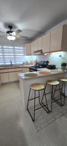 a kitchen with a counter and two stools in it at Boho Chic Relaxing Space in Fajardo +15 photos