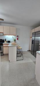 a kitchen with white cabinets and stainless steel appliances at Boho Chic Relaxing Space in Fajardo