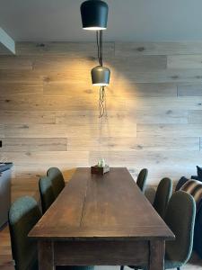 a dining room with a wooden table and chairs at Casa d'Alpe -Boutique apartment Chaberton view in San Sicario