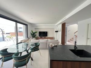 a kitchen and living room with a glass table and chairs at Casa Verde in Molino de las Ánimas
