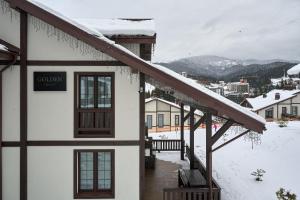 a building with a sign on it in the snow at Golden Chalet in Bukovel