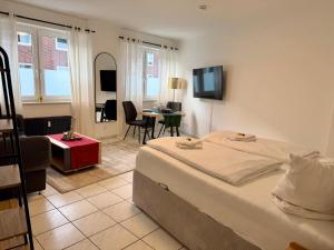 a bedroom with a bed and a living room at Modernes Studio im Herzen von Würselen, gemütlich, zentral & mit Netflix in Würselen