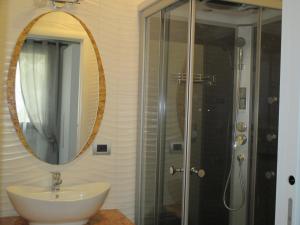 a bathroom with a sink and a shower with a mirror at Black and White in Cantù