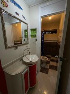ein Badezimmer mit Waschbecken, Toilette und Spiegel in der Unterkunft Casa turística Cartagena De Indias in Cartagena de Indias