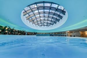 a pool in a building with a domed ceiling at ANS Hanza Tower Apartment no 410 - Swimming pool and saunas not opened from 12-28 November in Szczecin