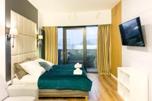 a living room with a bed and a tv at ANS Hanza Tower Apartment no 410 - Swimming pool and saunas not opened from 12-28 November in Szczecin